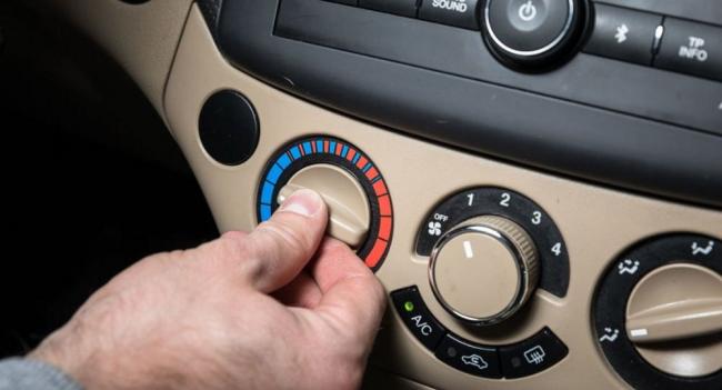 Регулировка температуры в салоне автомобиля Мужчина поворачивает рычаг отопителя