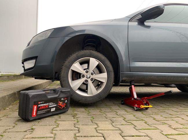 Поднятый перед автомобиля на домкрате Автомобиль на домкрате