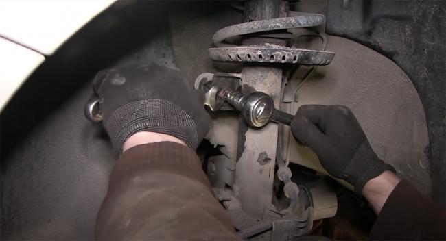 Откручивание гайки, скрепляющей стойку и кузов автомобиля Гайка и стойка