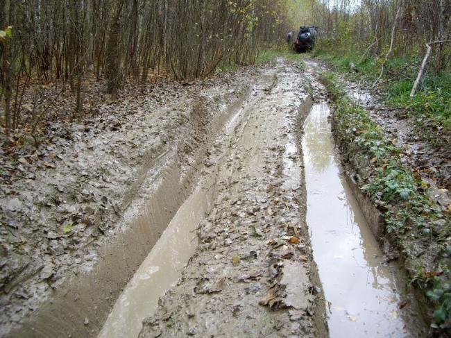 Глубокая колея с грязью и водой Глубокая колея