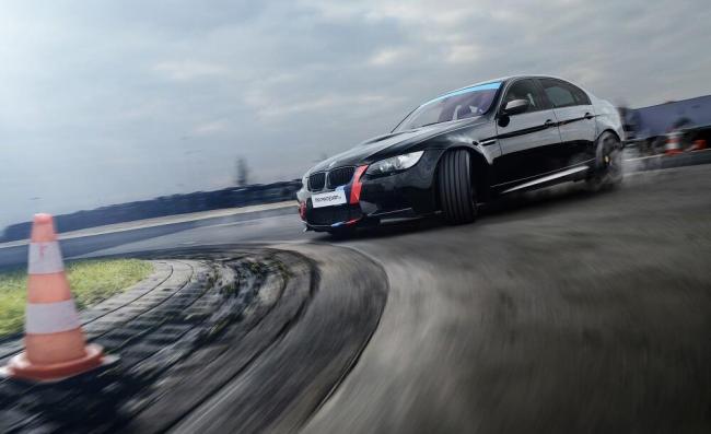 Автомобиль в управляемом заносе Гоночный автомобиль на трассе