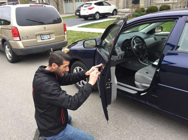 Самостоятельный ремонт двери машины Мужчина чинит дверь машины