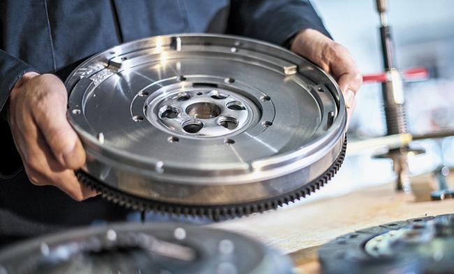 Что такое двухмассовый маховик Мужчина держит двухмассовый маховик