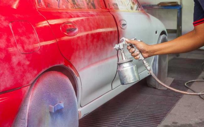 Самостоятельная покраска автомобиля Мужчина красить автомобиль