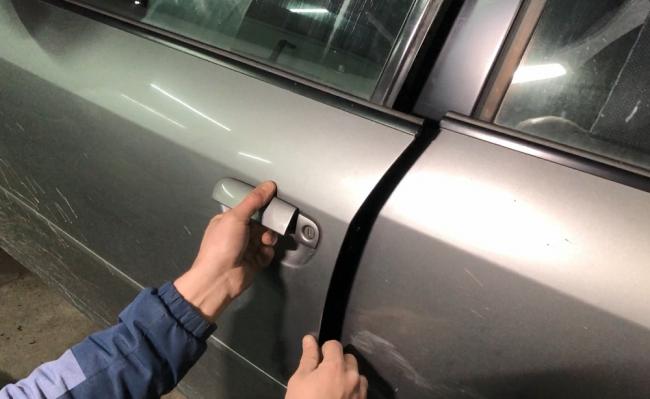 Диагностика дверей автомобиля Мужчина смотрит автомобильную дверь
