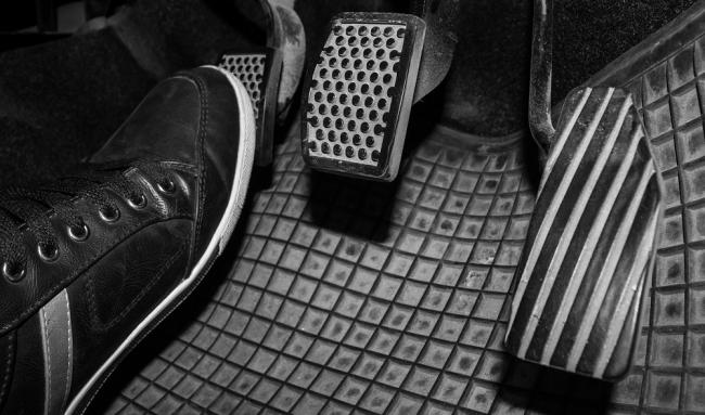 Водитель выжимает сцепление Нога на педали сцепления