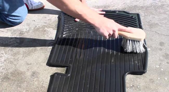 Чистка автомобильного коврика с помощью щётки Очистка автомобильного коврика щёткой