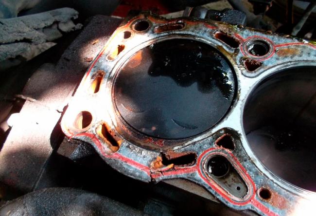 Фотография пробитой прокладки ГБЦ Пробитая прокладка ГБЦ